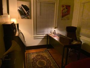 - un bureau dans une chambre dotée d'une fenêtre et d'une table avec un ordinateur portable dans l'établissement Dr. Yaple's Art Deco House, à Lafayette