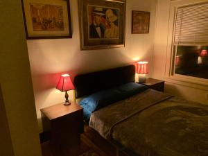 a bedroom with a bed and two tables with lamps at Dr. Yaple's Art Deco House in Lafayette