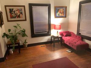 sala de estar con sofá rojo y mesa en Dr. Yaple's Art Deco House, en Lafayette