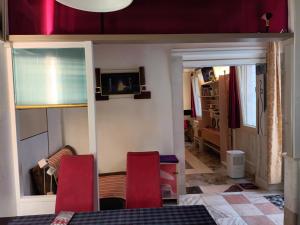 a living room with two red chairs and a table at Tiepolo's Apartment in Venice