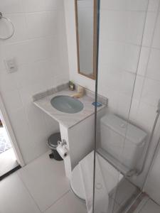 une salle de bain avec un lavabo, des toilettes et un miroir dans l'établissement Pousada Sweet Home, à Búzios