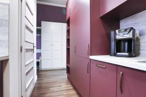 a kitchen with purple cabinets and a kitchen appliance at Two-bedroom Haven In The Old Town in Prague