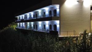 a building with lights on the side at night at BellaVista in Capo Vaticano
