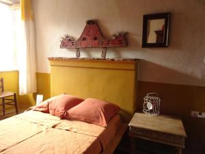 a bedroom with a bed with a red and yellow headboard at Authentique maison de village de Gavignano 