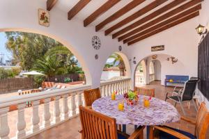 a dining room with a table and chairs on a balcony at Villa Capricho - PlusHolidays in Calpe