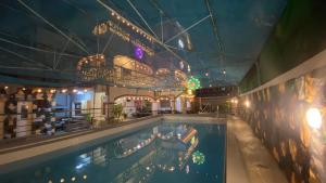 una piscina en un hotel con una lámpara de araña en villa paguio hot spring resort, en Calambá