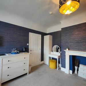 um quarto com uma cómoda branca e uma lareira em The Corner House em Lowestoft