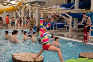 Una joven que se pasea por una escalera en una piscina en NEW High Saddle Getaway, en Sheridan