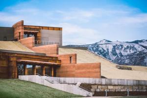 un edificio en una colina con montañas al fondo en NEW High Saddle Getaway, en Sheridan
