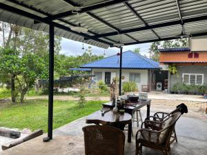 a patio with a table and chairs under a pergola at สวนสน โฮมสเตย์ in Mae Hong Son