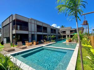 a swimming pool in front of a building at TOCA GAMBOA in Pôrto de Pedras