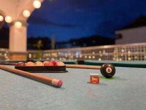 a billiard table with three balls and two cue sticks at villa paguio hot spring resort in Calamba