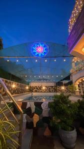 una piscina por la noche con un techo iluminado en villa paguio hot spring resort, en Calambá