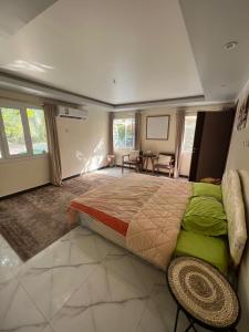 1 dormitorio con 1 cama grande y 1 mesa en استراحة شرفة الواحةOasis Terrace Inn and Lounge, en Bahlāʼ