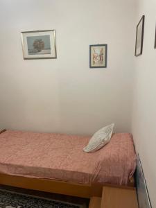 sypialnia z łóżkiem i 2 zdjęciami na ścianie w obiekcie La Cascina fuori Porta w mieście Castel San Pietro Romano