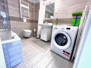 een badkamer met een wasmachine en een wastafel bij BUDAPEST DOWNTOWN RESIDENCES LEO - AC, ELEVATOR, TERRACE in Boedapest
