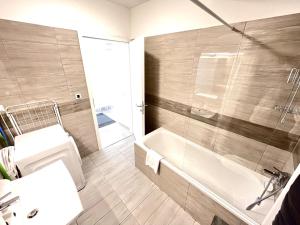 a bathroom with a tub and a sink and a shower at BUDAPEST DOWNTOWN RESIDENCES LEO - AC, ELEVATOR, TERRACE in Budapest