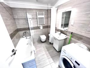 a bathroom with a tub and a toilet and a sink at BUDAPEST DOWNTOWN RESIDENCES LEO - AC, ELEVATOR, TERRACE in Budapest