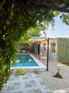 una piscina en un patio con una casa en استراحة شرفة الواحةOasis Terrace Inn and Lounge, en Bahlāʼ