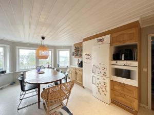 una cucina con tavolo e frigorifero di Very nice villa in northwestern Orust a Henån