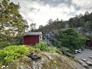 a small red building on a hill with a waterfall at Very nice villa in northwestern Orust in Henån