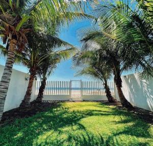 a group of palm trees in front of a building at Casa Trébol: Tu Casa de Playa. Disfruta en familia in Puerto Arista