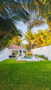 a house with a swimming pool and palm trees at Casa Trébol: Tu Casa de Playa. Disfruta en familia in Puerto Arista