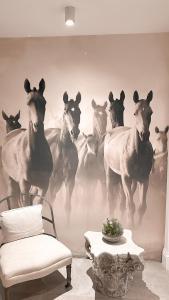 ein Bild von Pferden, die an einer Wand rennen in der Unterkunft Havuzlu , şömineli villa 