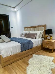a bedroom with a bed and a night stand with a rug at Appartement de luxe centre-ville in Rabat