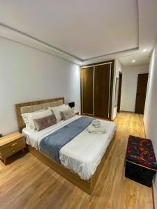 - une chambre avec un grand lit et du parquet dans l'établissement Appartement de luxe centre-ville, à Rabat