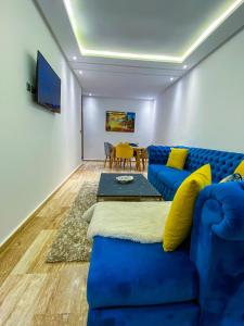 un soggiorno con divano blu e tavolo di Appartement de luxe centre-ville a Rabat