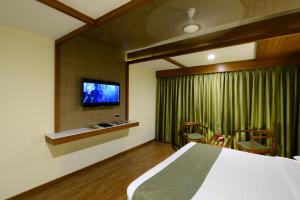 a bedroom with a bed and a flat screen tv at Taj Mahal Hotel in Hyderabad