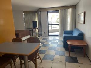 - un salon avec un canapé bleu et une table dans l'établissement Flat Iate Plaza, à Fortaleza
