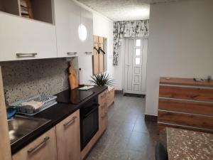 a kitchen with white cabinets and a black counter top at Studio Primani in Sečovlje +4 photos
