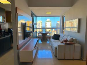 a living room with a couch and a view of the city at Duplex Penthouse with Jacuzzi and Private BBQ in Itaparica