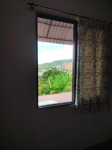 ventana en una habitación con vistas al jardín en Cómodo estudio en la vía a termales, en Santa Rosa de Cabal