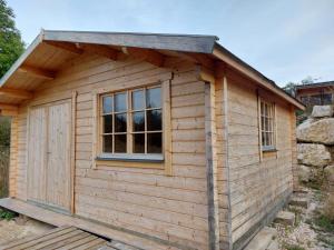 uma cabana de madeira com uma janela e uma porta em Petit Chalet Nature em Les Rousses