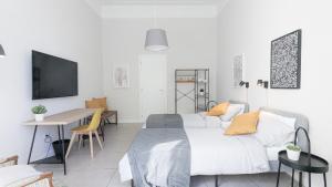 Casa Doclea _Comfort & relax nel cuore della città في نابولي: غرفة معيشة مع سرير أبيض وطاولة