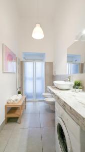Casa Doclea _Comfort & relax nel cuore della città في نابولي: حمام مع مغسلتين وغسالة ملابس