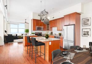 a kitchen and living room with a refrigerator and a table at Glorious 3 Bed 2 Bath In Upper East Side in New York