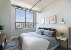 a bedroom with a bed and a large window at Glorious 3 Bed 2 Bath In Upper East Side in New York