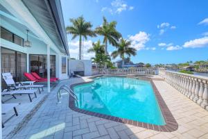 - une piscine sur une terrasse à côté d'une maison dans l'établissement Villa Waterview - Amazing Gulf access pool and spa home on spacious corner lot!, à Cape Coral