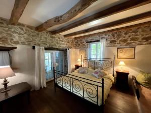 um quarto com uma cama e uma parede de pedra em La Vigne, fully modernised farmhouse dated 1882 