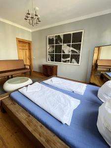 uma grande cama azul num quarto com uma mesa em Homeplanet Hostel em Leipzig