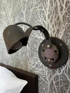 une lampe noire sur un mur à côté d'un lit dans l'établissement Homeplanet Hostel, à Leipzig