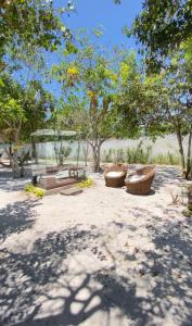 um parque com duas mesas de piquenique e árvores em Pousada Alta Caraíva em Caraíva
