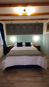 a bedroom with a large bed with a blue wall at La Flor del Camino Posada in Tanti