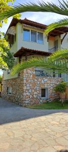 a large house with a stone wall at Villa Dimitrios(2 independent apartments 200sq m) in Vourvourou