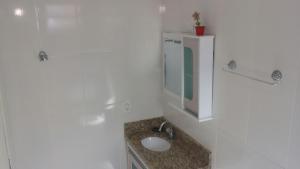 ein Badezimmer mit Waschbecken und Spiegel in der Unterkunft Casa Bombinhas temporada in Bombinhas + 14 Fotos