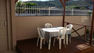 ボンビーニャスにあるCasa Bombinhas temporadaの白いテーブルと椅子付きのバルコニー
